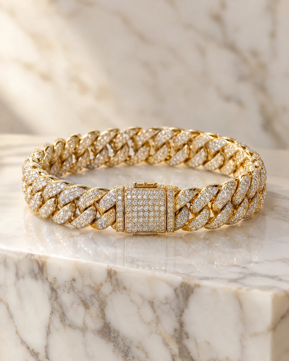 Iced-out yellow gold diamond Cuban link bracelet, clasped, on a white marble block